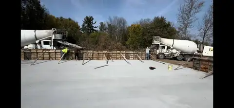 Concrete being poured into wooden forms at a construction site