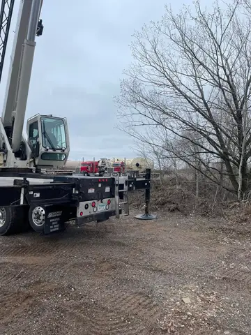 Concrete pump truck positioned near trees for site work