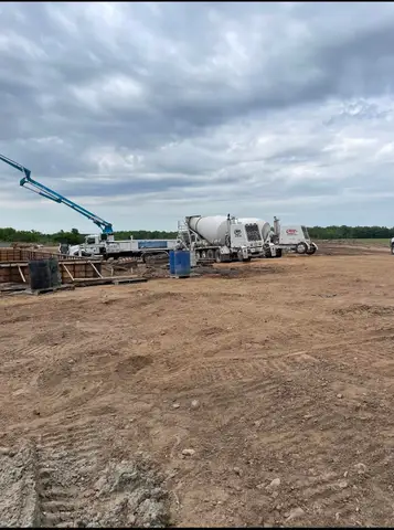Concrete mixer truck parked at a construction site with workers