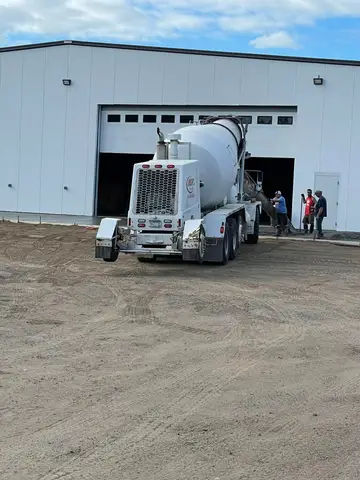 Concrete mixer truck unloading at a building site in Gilman