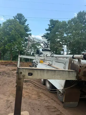 Concrete pump truck positioned for pouring concrete at a site