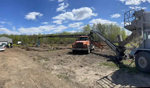 Excavation and concrete pouring at a construction site in Gilman